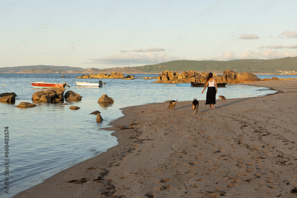 Young Galician woman walking dogs on beach Young Galician woman walking dogs on beach