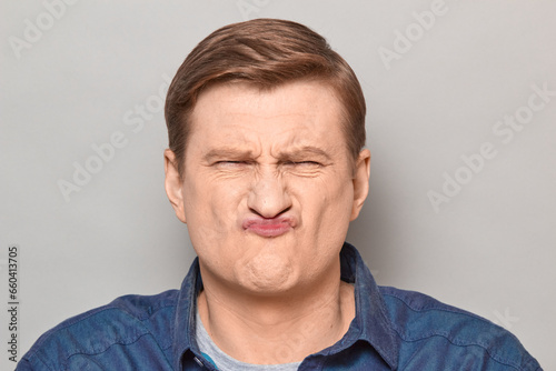 Portrait of funny disgruntled man making goofy crazy face