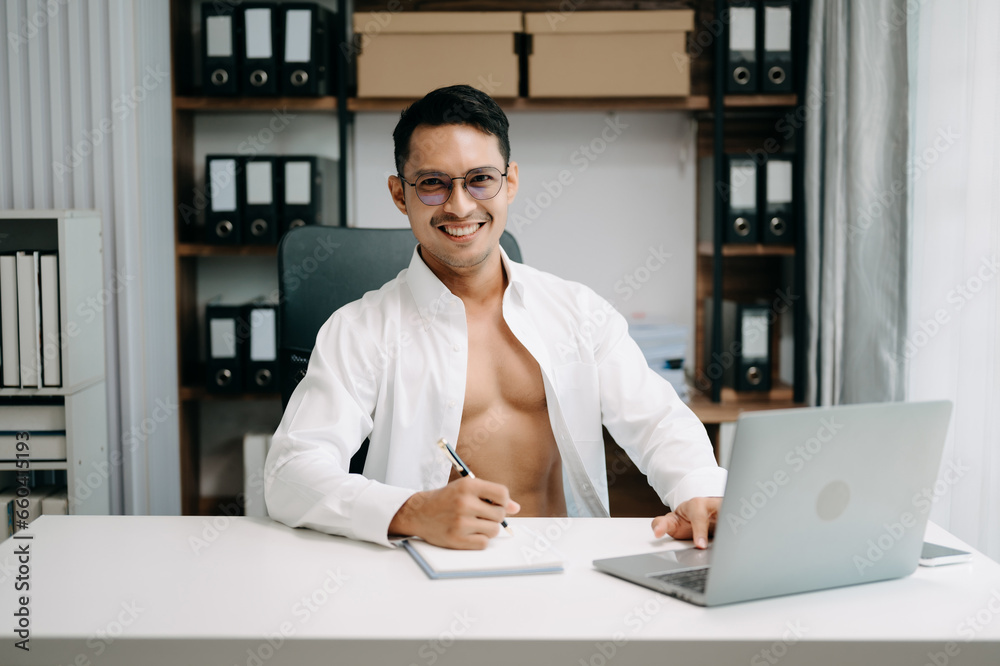 .Young handsome man working at office with laptop, tablet and taking notes on the paper. .Young handsome man working at office with laptop, tablet and taking notes on the paper.