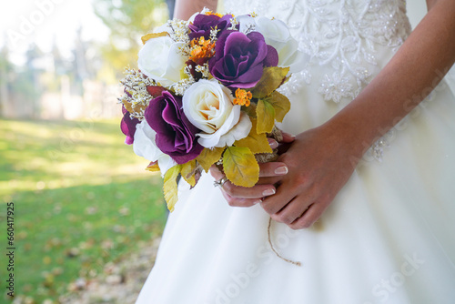bride holding a purple and white wedding bouquet of flowers. Bride with wedding bouquet 