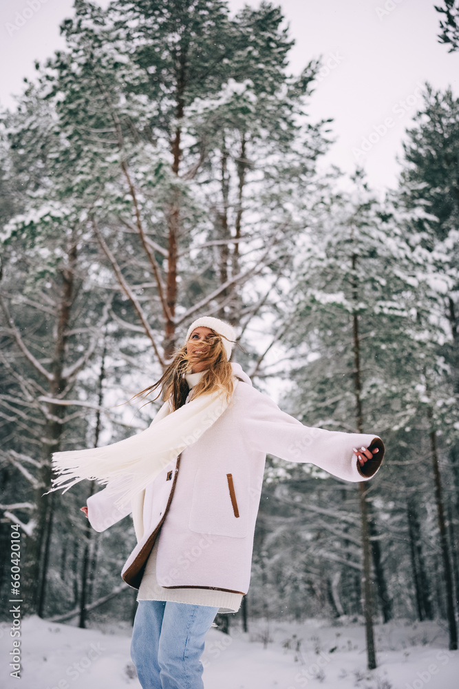 Active beautiful young woman in white clothes enjoying snowy winter forest Active beautiful young woman in white clothes enjoying snowy winter forest