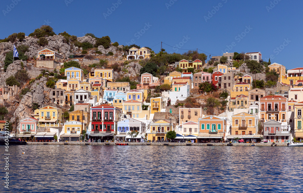 Colorful traditional multi-colored houses on the shore of the bay on Symi island.