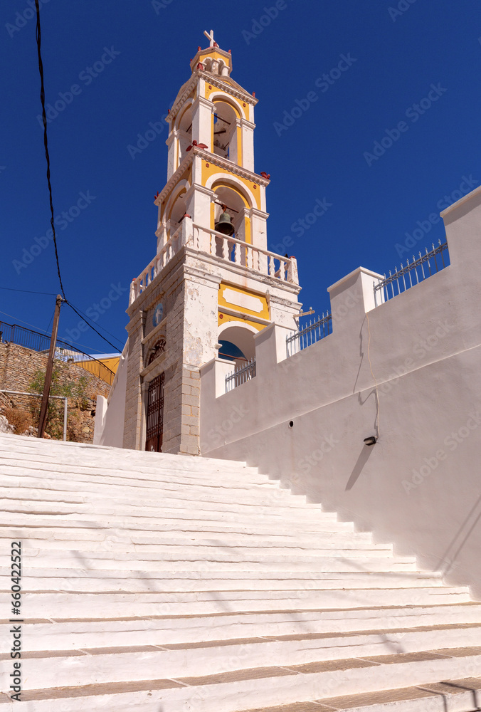 Bell tower of a traditional Greek Orthodox church on a narrow street of Symi island.