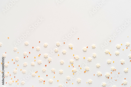 White sugar sweet snowflakes sprinkles on white background. Sweet backing decoration for cake and candy.Copy space. 