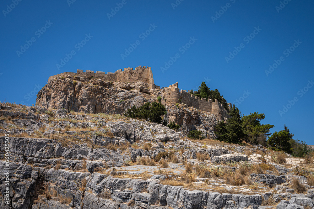 The Ascent to the Acropolis of Lindos: A path steeped in history, revealing the splendors of Rhodes Island and the shimmering Mediterranean with every step.