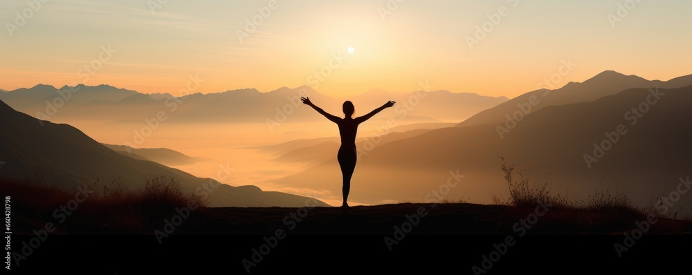 A person celebrating on a hilltop with arms raised in joy