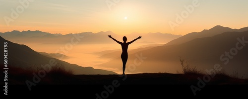 A person celebrating on a hilltop with arms raised in joy