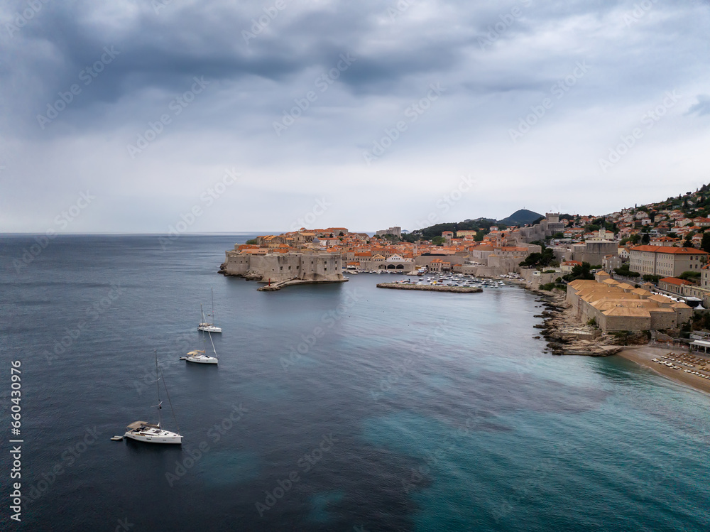 Amazing panoramic view of the famous city of Dubrovnik in Croatia, old town with city walls, houses with red roofs, historical buildings surrounded by turquoise sea