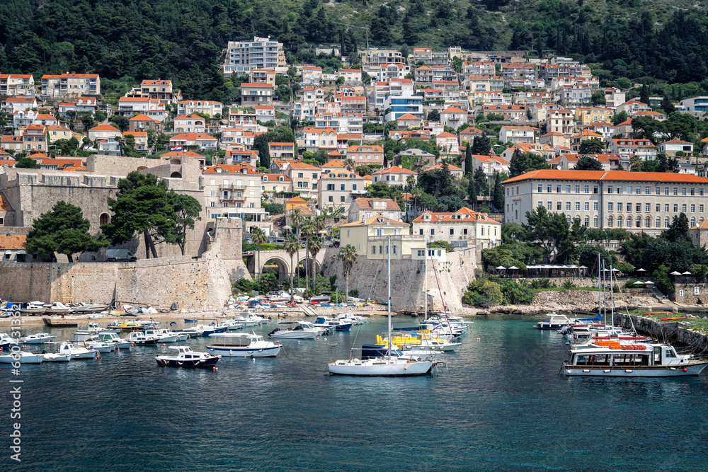 Beautiful view with the harbor with boats in the bay in front of the city walls of the old town of Dubrovnik, Croatia