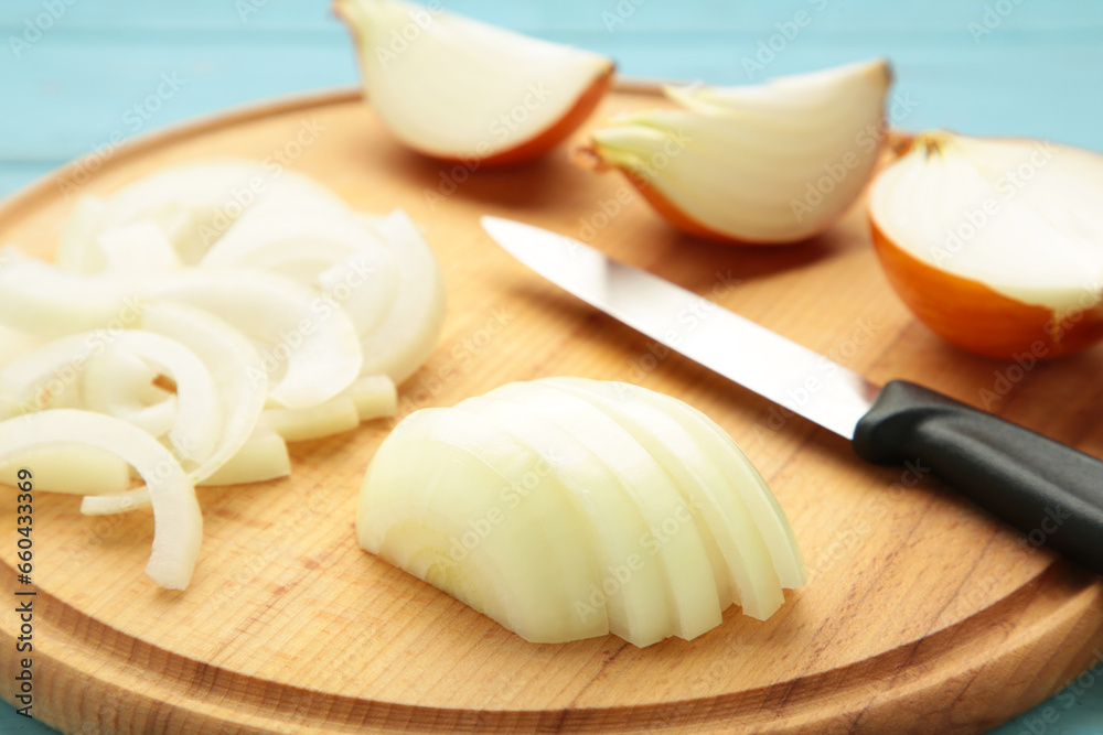 Whole and sliced yellow onions on wooden cutting board. Whole and sliced yellow onions on wooden cutting board.
