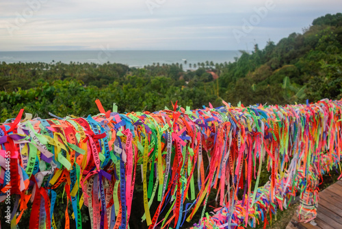 Arraial Dajuda, Bahia, Brazil: colorful souvenir ribbons hanging on the railing, sea on background