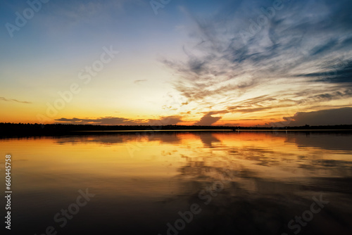 Vibrant sky reflecting on a calm and serene lake © pobaralia