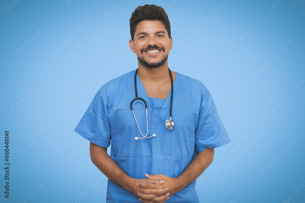 Handsome hispanic male nurse with beard on blue background Handsome hispanic male nurse with beard on blue background