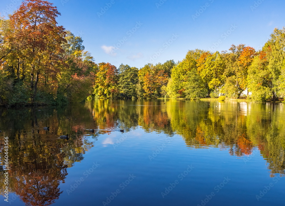 Parks of St. Petersburg. The first days of autumn. Reflection of trees in water.