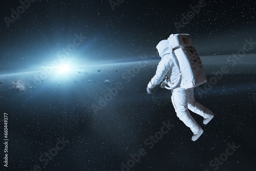 Fototapeta Naklejka Na Ścianę i Meble -  Cosmonaut in deep space with sun light. Elements of this image furnished by NASA.