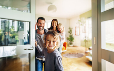 A friendly family welcomes guests at the door of their new home. A young boy holds the door open and smiles at the camera. Behind him we see his smiling family and the bright interior. Generative ai