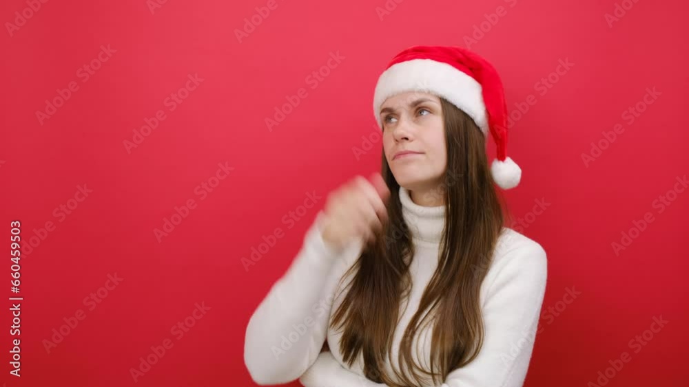 Pensive young woman wears white sweater and Xmas Santa hat looking aside on workspace area scratch hold head, posing isolated on red studio background. Happy New Year 2024 celebration holiday concept Pensive young woman wears white sweater and Xmas Santa hat looking aside on workspace area scratch hold head, posing isolated on red studio background. Happy New Year 2024 celebration holiday concept