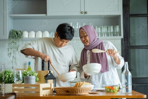 Canvas Print Cute son And His Muslim Mom In Hijab Preparing Pastry For Cookies In Kitchen, Baking Together At Home