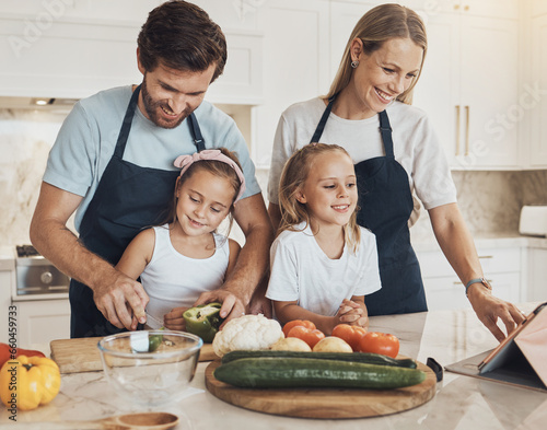 Happy, cooking and family in the kitchen together for bonding and preparing dinner, lunch or supper. Love, smile and girl children cutting vegetables or ingredients with parents for a meal at home.