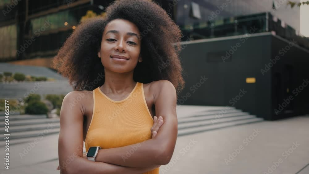 Woman in sportswear standing at city with crossed arms Woman in sportswear standing at city with crossed arms