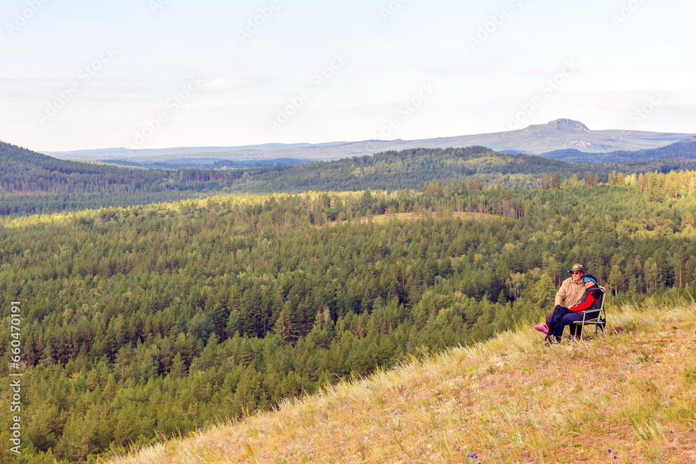 beautiful mature couple on the slope of the mountain of the southern Urals on a summer day beautiful mature couple on the slope of the mountain of the southern Urals on a summer day