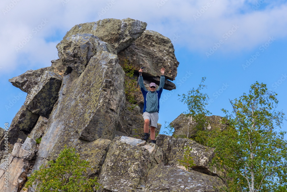 young handsome man Tourist travels along the rocks of the Southern Urals on a summer day
