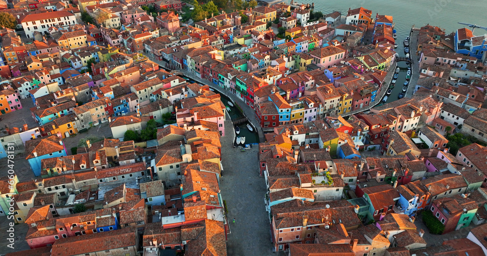 Aerial view of Burano colorful houses, along the Fondamenta embankment, featuring fishing boats and bridges, Venice, Italy at sunrise golden hour