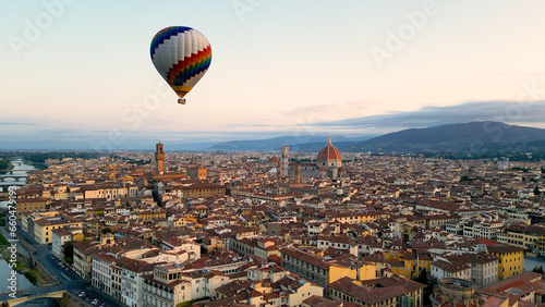 Florence, Colorful hot air balloon epic flying above the city at sunrise, Cathedral of Saint Mary of the Flower, Palazzo Vecchio, Tuscany, Italy