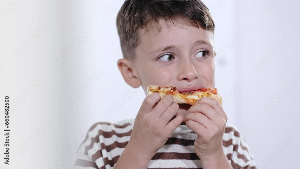 Little boy deliciously eating salami pizza Little boy deliciously eating salami pizza