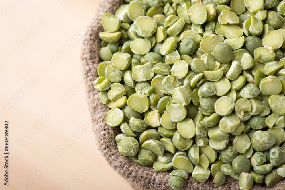 Close up of dry green pea beans in small bag with wooden background. Dehydrated green pea in linen sack Close up of dry green pea beans in small bag with wooden background. Dehydrated green pea in linen sack