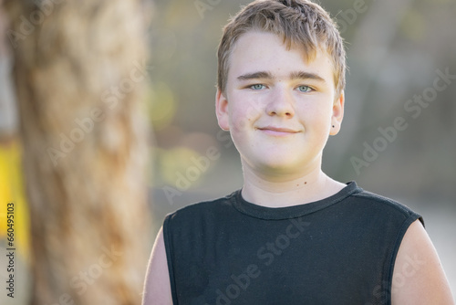 Portrait of pre-teen boy with wry smile in nature photo