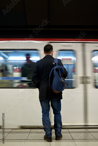 Young man standing in front of subway train
