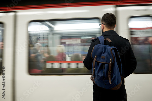 Young man standing in front of subway train