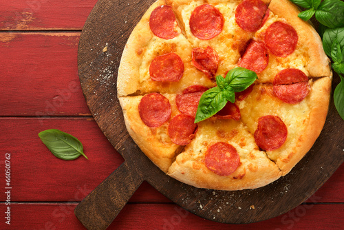 Pepperoni pizza. Traditional pepperoni pizza and cooking ingredients tomatoes basil on wooden table backgrounds. Italian Traditional food. Top view. Mock up.
