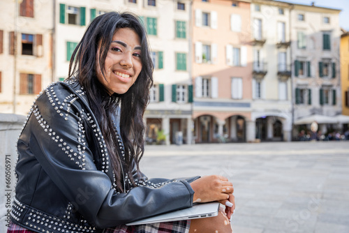Canvastavla An hispanic girl with vitiligo sitting in the city center smiles