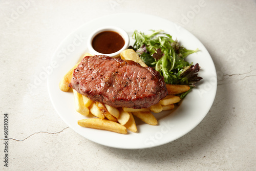 Black angus sirloin steak with fries and salad photo