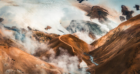 Landscape of Kerlingarfjoll volcanic mountain range with sulfur smoke and tourist hiking in summer at Icelandic Highlands
