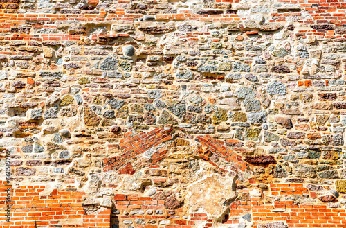 Ancient weathered red brick and stone wall of Novgorod Kremlin as creative background