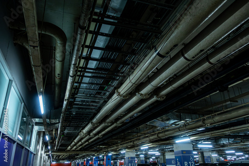 Pipelines in the underground parking of a petroleum and gas refinery run along the ceiling, servicing the industrial complex