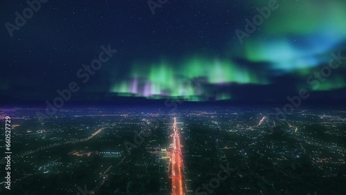 Aerial view of huge city at night time. Aurora light effect at the sky. Fantastic and epic cityscape. photo