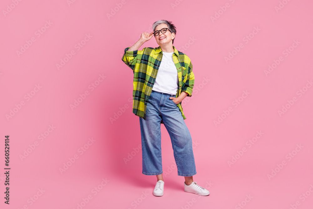 Full size photo of positive person with gray hair dressed plaid shirt look empty space touch glasses isolated on pink color background Full size photo of positive person with gray hair dressed plaid shirt look empty space touch glasses isolated on pink color background