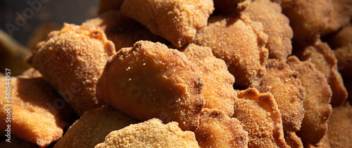 Appetizing rissoles filled with meat or shrimp at a traditional Portuguese food festival. Snack indulgence background. Closeup. Selective focus.
