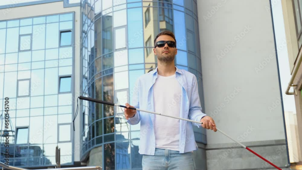 Blind man setting up walking cane on the street near the business center Blind man setting up walking cane on the street near the business center