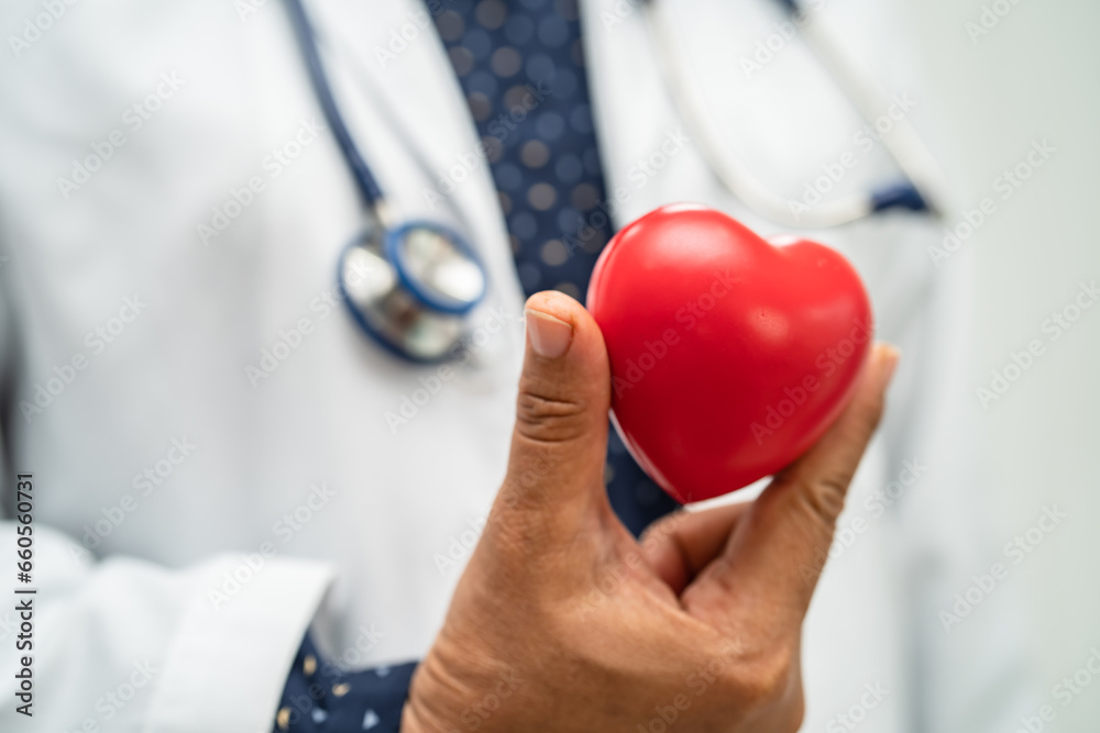 Doctor holding a red heart in hospital ward, healthy strong medical concept. Doctor holding a red heart in hospital ward, healthy strong medical concept.