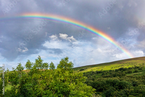 A rainbow over the slopes of Dunkery Beacon on Exmoor National Park from Cloutsham, Somerset, England UK