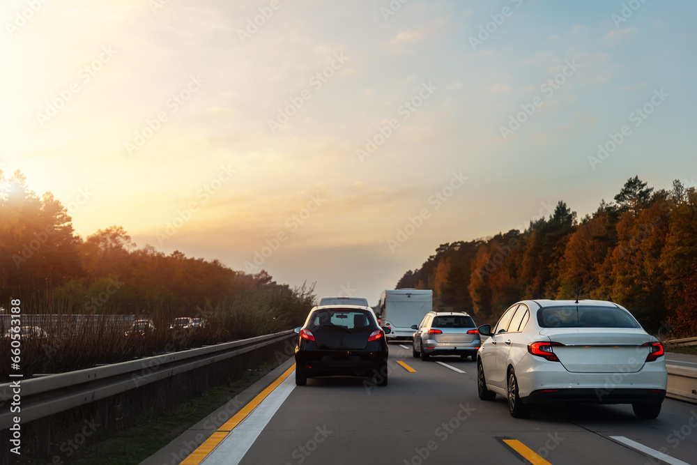 Back tail view of many cars stuck in row at highway city street road traffic jam warm sunset time. Automobile accident vehicle rush hour collapse. Town transport commute infrastructure blockage strike