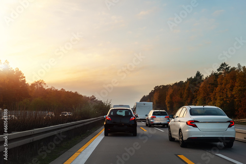Back tail view of many cars stuck in row at highway city street road traffic jam warm sunset time. Automobile accident vehicle rush hour collapse. Town transport commute infrastructure blockage strike