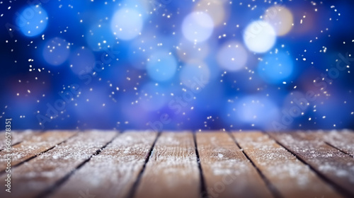Winter wooden table covered with snow, blue bokeh background, copy space