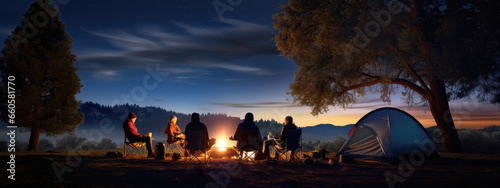 Family with kids looks up at the night sky and stars next to their tent in nature