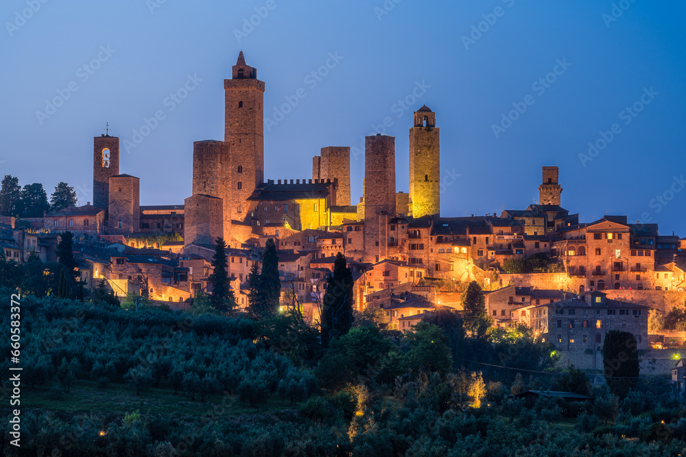 The marvelous city of San Giminiano with all its towers illuminated on a summer evening. Province of Siena, Tuscany, Italy.